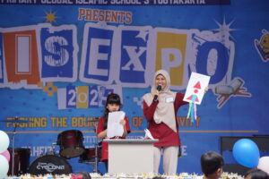 Seorang siswa dan gurunya sedang mempresentasikan hasil karyanya