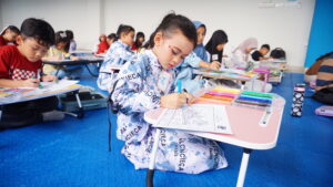 Seorang peserta lomba coloring tampak serius mewarnai gambarnya
