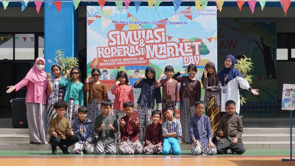 Keceriaan siswa-siswi ketika berfoto dengan kedua wali kelasnya di kegiatan Simulasi Koperasi