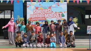Keceriaan siswa-siswi ketika berfoto dengan kedua wali kelasnya di kegiatan Simulasi Koperasi