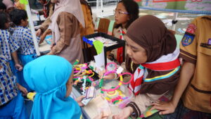 Seorang siswi sedang menawarkan produknya kepada siswa lain yang ingin membeli