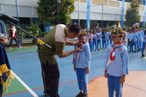 Mr. Adam, Wakil Kepala Sekolah Primary, sedang menyematkan emblem TKK kepada siswa