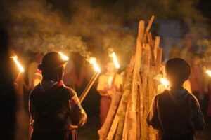 Malam hari, perwakilan siswa berdiri melingkar sembari membawa obor untuk menyalakan api unggun