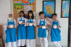 Dengan penuh rasa bangga, siswa memamerkan mi buatannya yang telah dikemas ke dalam wadah