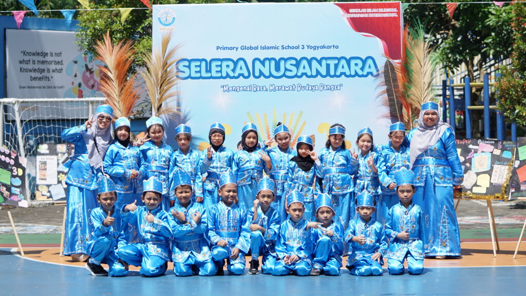 Mengenakan pakaian daerah Sulawesi Utara, siswa dan guru kelas 3D berfoto bersama di lapangan