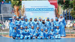 Mengenakan pakaian daerah Sulawesi Utara, siswa dan guru kelas 3D berfoto bersama di lapangan