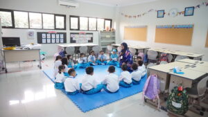 Potret siswa grade 1 berkumpul di kelas bersama wali kelasnya