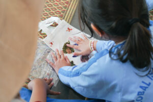 Seorang anak sedang menata dedaunan untuk membuat ecoprint