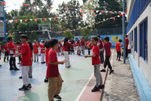 Anak-anak dari upper class bekerja sama dalam lomba estafet cone