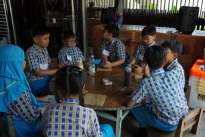 Anak-anak duduk melingkar, siap berkreasi menggunakan gerabah
